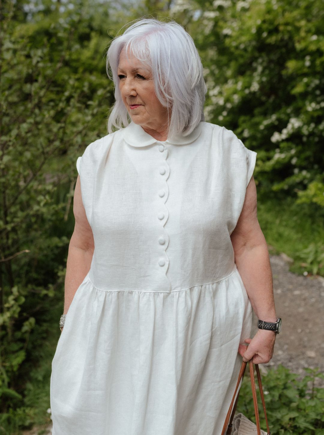 White linen dress with scalloped detail and covered buttons
