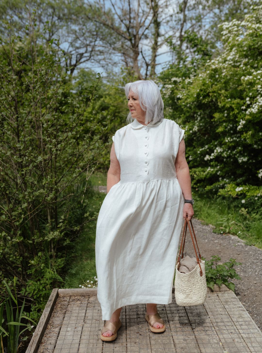 White linen dress with scalloped detail and covered buttons
