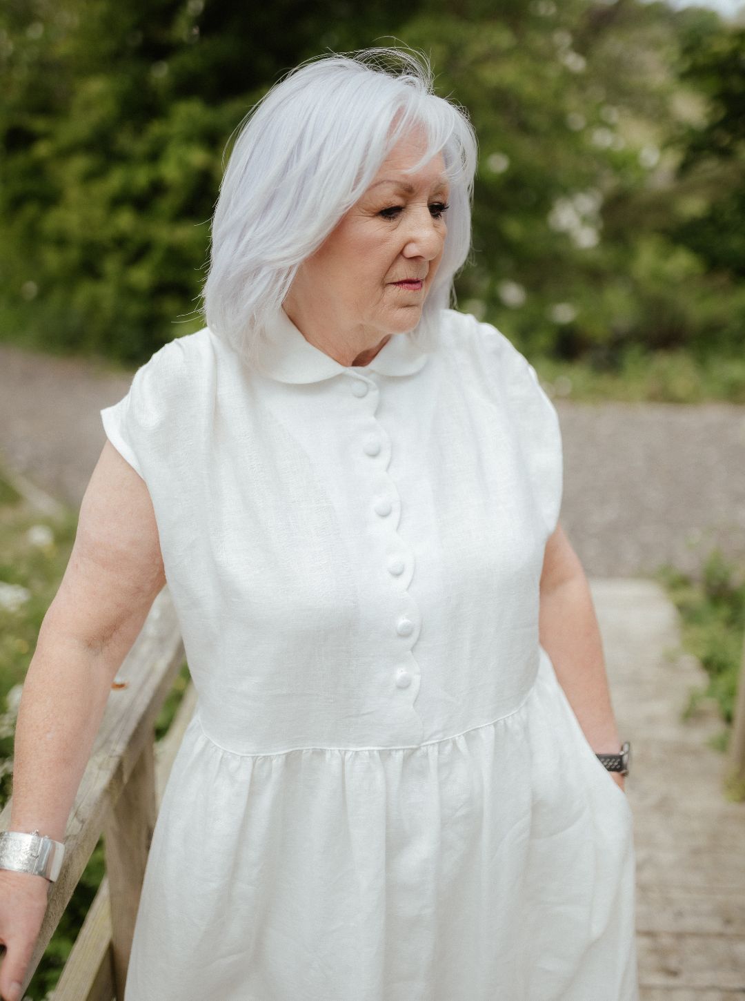 White linen dress with scalloped detail and covered buttons