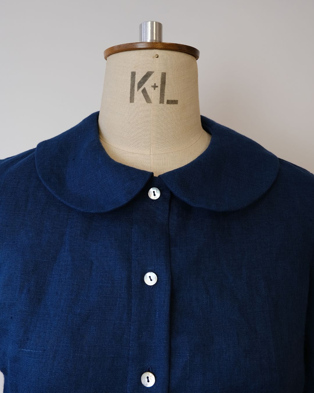 Navy blue shirt on a mannequin with 'K+L' branding.