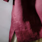 Close-up of a maroon fabric with a textured pattern on a plain background