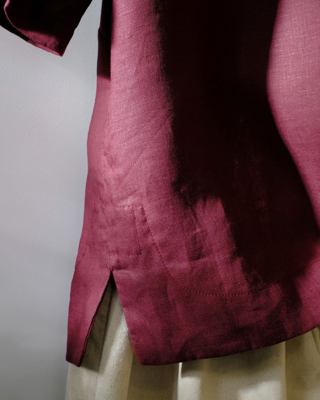 Close-up of a maroon fabric with a textured pattern on a plain background