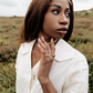 Woman wearing a cream linen blouse  standing in a moorland setting.