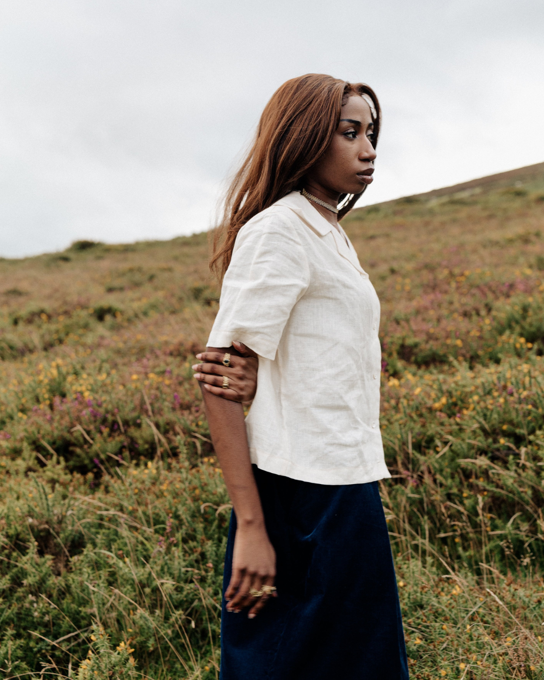 A woman outdoor wearing a cream linen blouse with a collar, 