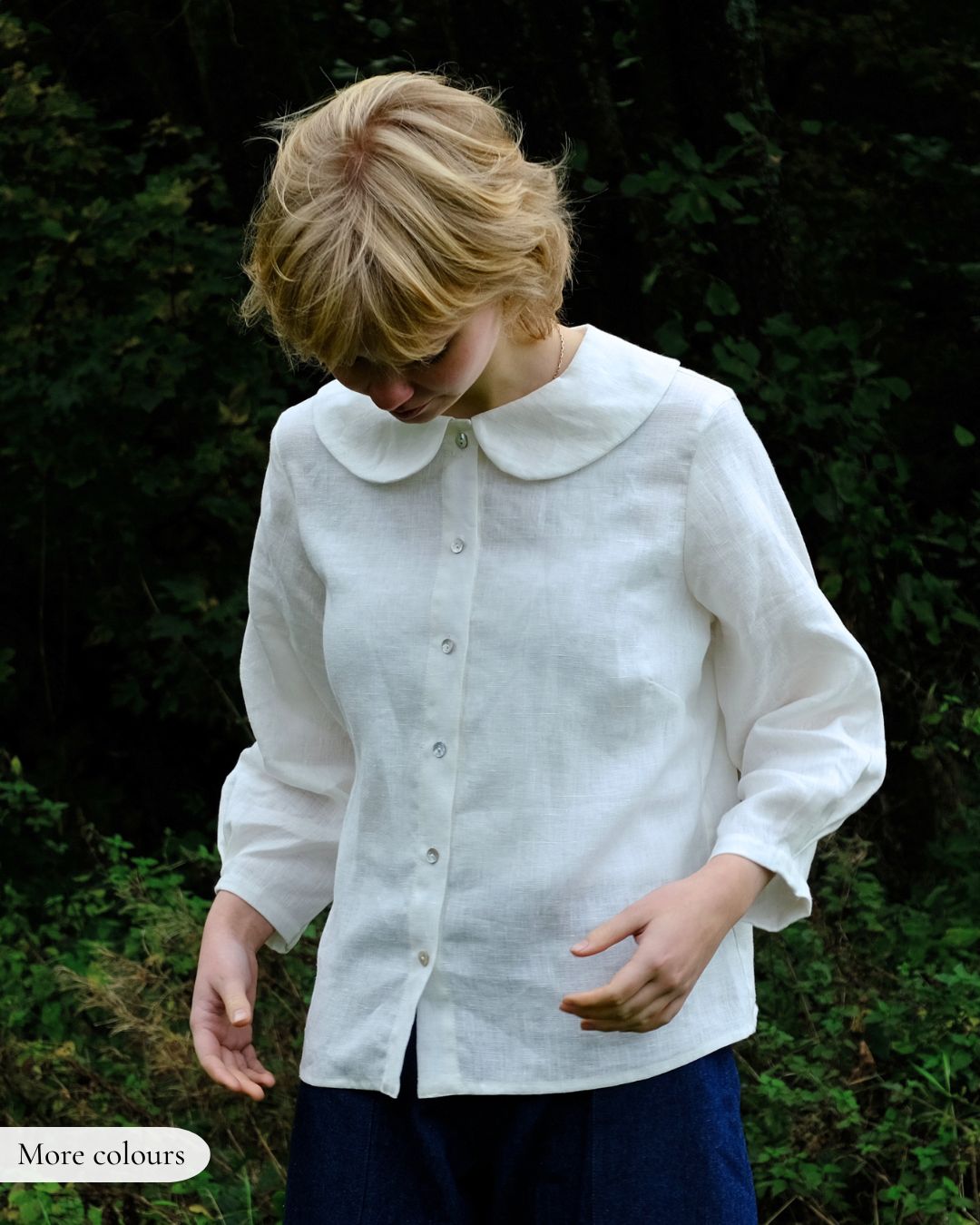 Woman wearing a white blouse with a collar in a natural setting