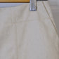 Close-up of beige fabric with a metal clip on a wooden hanger.