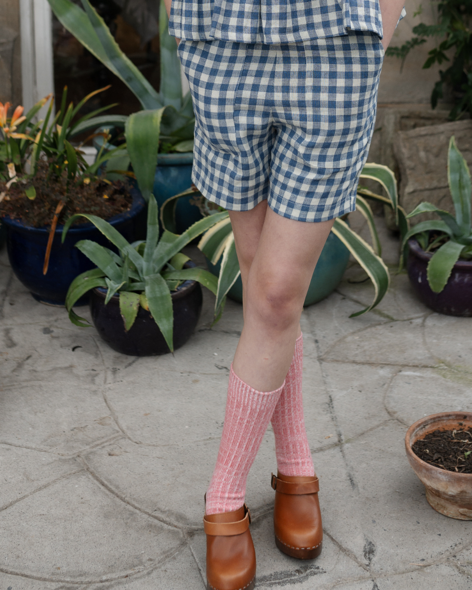 A pair of easy fit pull-on shorts in a checkered pattern, with a flat front waistband and elasticated back waist, featuring deep patch pockets to the front.