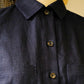 Close-up of a dark blue shirt with buttons on a mannequin against a neutral background