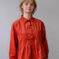 Person wearing a red jacket against a plain background