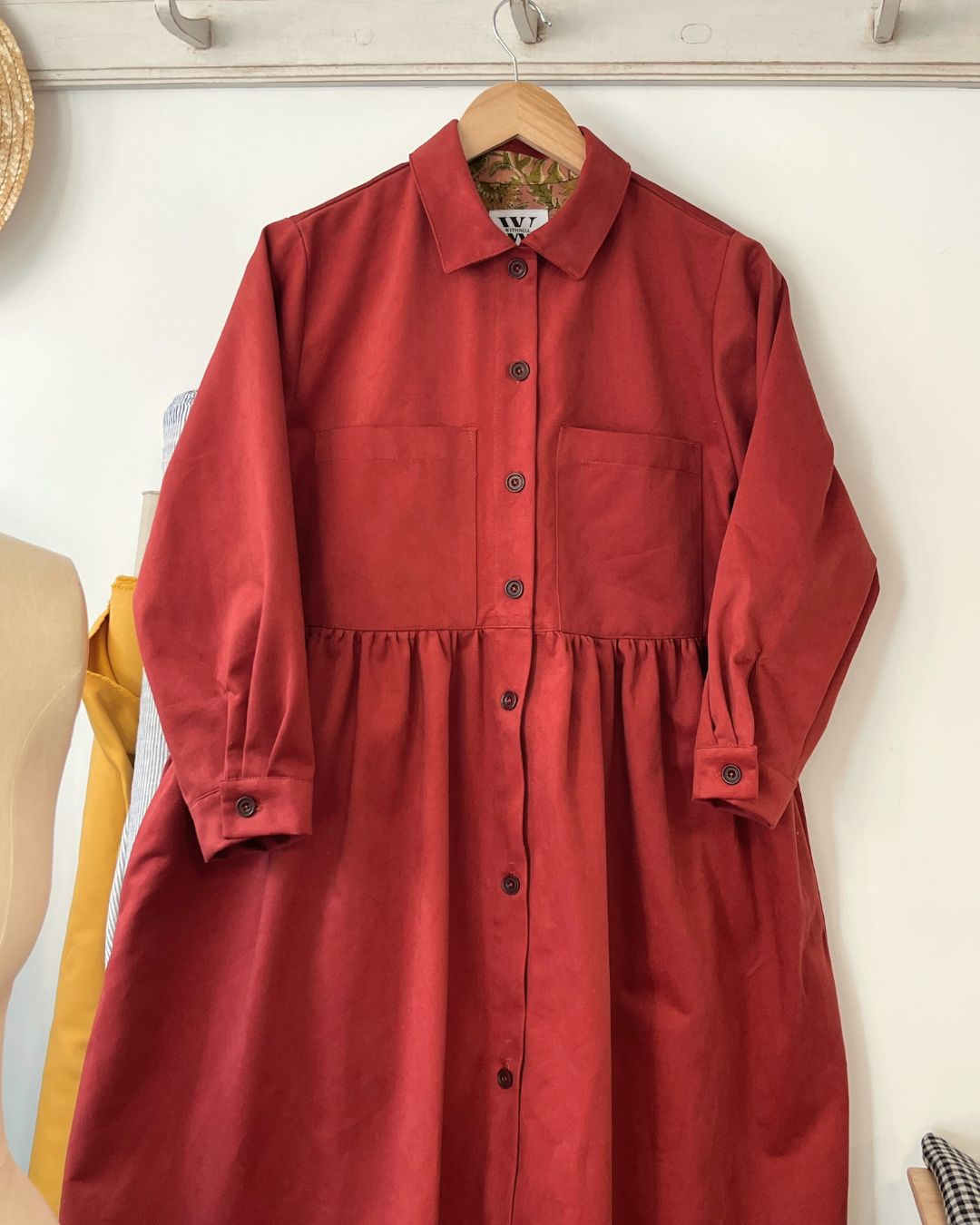 Red dress on a hanger against a white wall