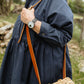 Person wearing a navy Dorothy shirtdress  with a woven bag over their shoulder in a natural setting.
