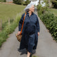 Woman in a blue dress walking along a path in a rural setting