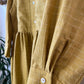 Close-up of a mustard yellow checkered dress with buttons.