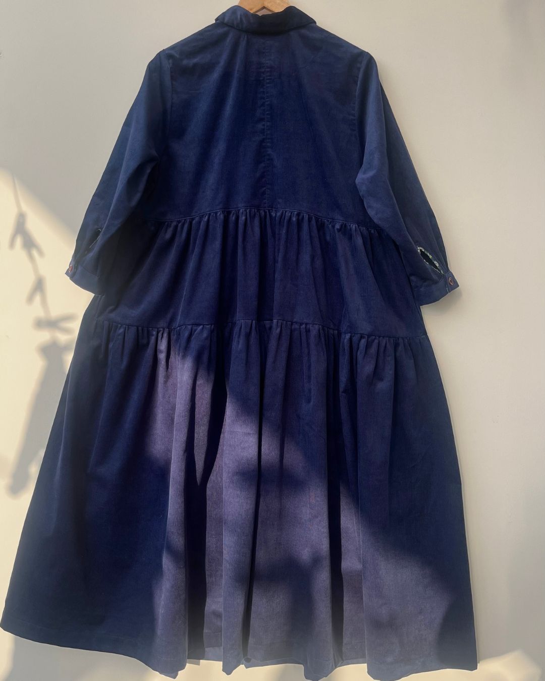 Navy blue dress with a layered skirt on a white background