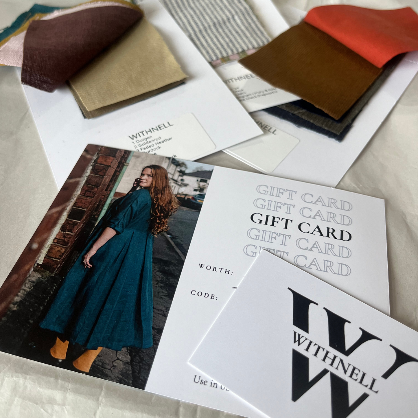 Gift card with some fabric swatches on a cream background