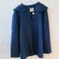 Blue sweater with a collar on a hanger against a white background
