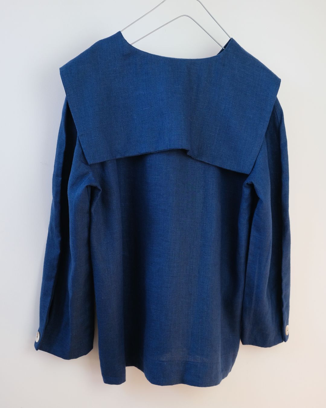 Blue top with a unique design on a white background