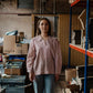 Woman standing in a warehouse with shelves and boxes in the background