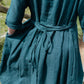 Teal dress with a belt being worn outdoors