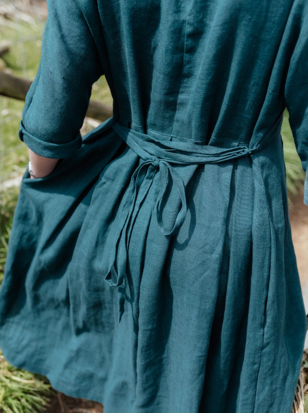 Teal dress with a belt being worn outdoors