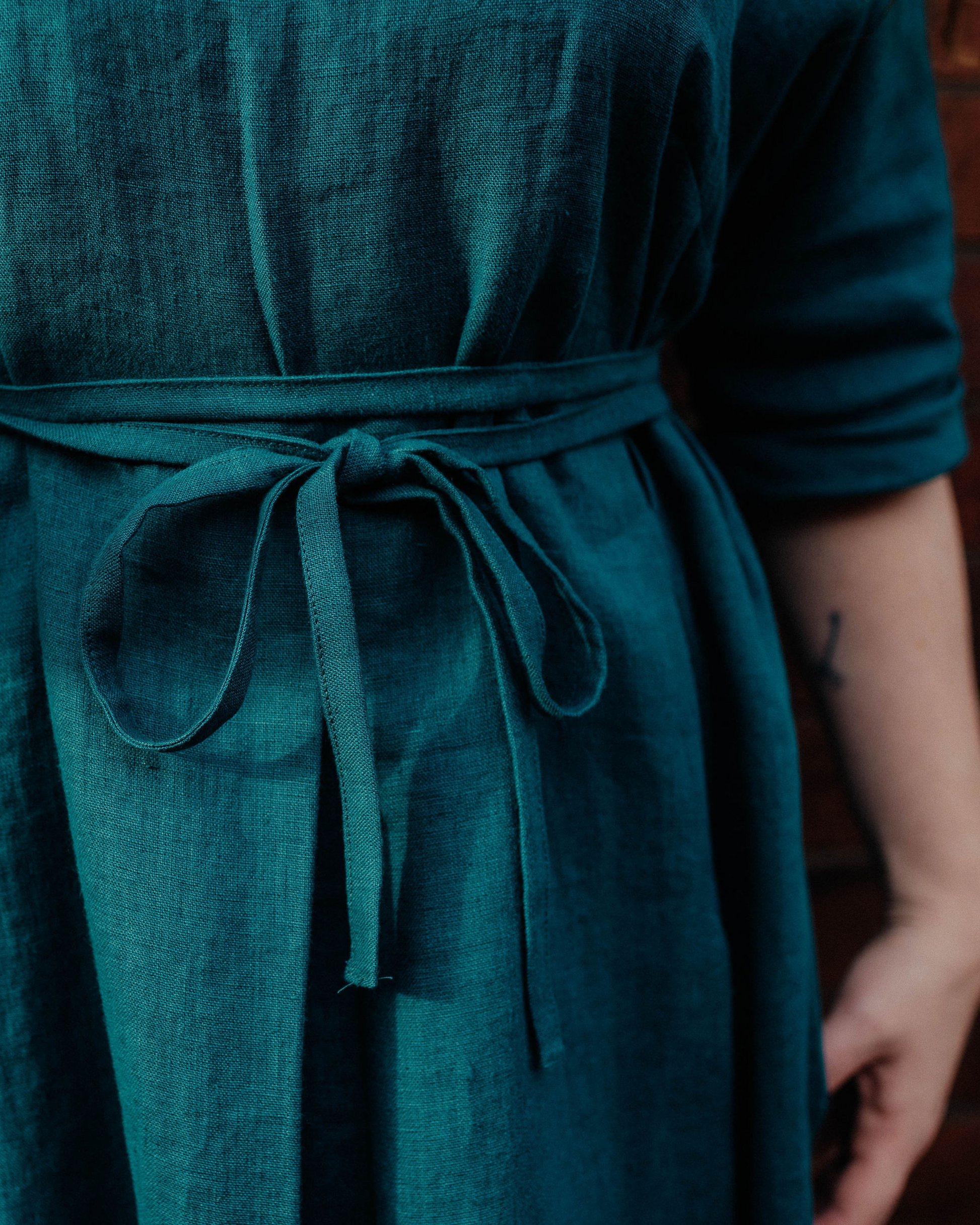 close up of teal blue dress fabric with tied waist.