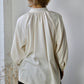 person standing with back view of white blouse.
