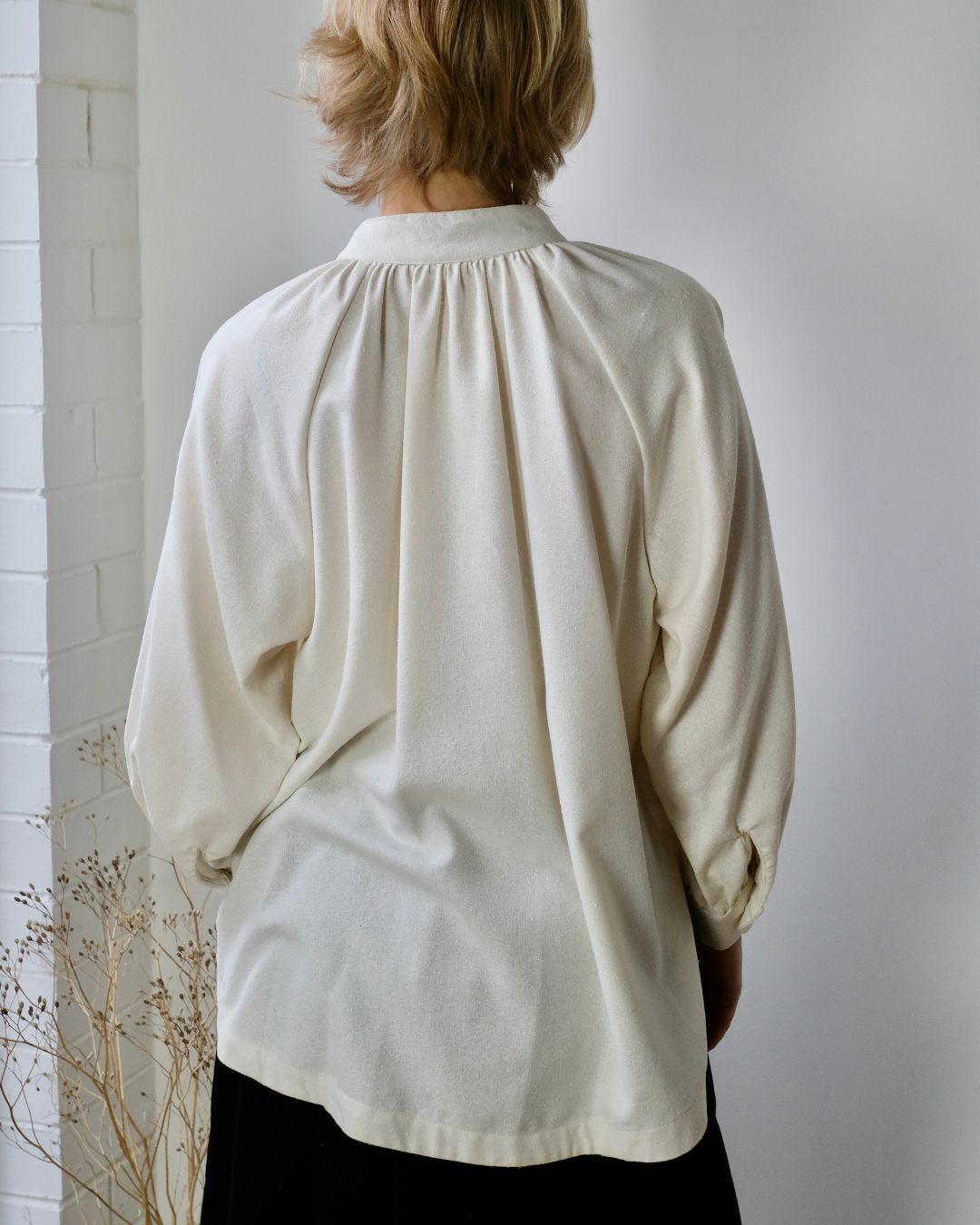 person standing with back view of white blouse.