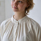close up of person wearing shirt with rounded collar