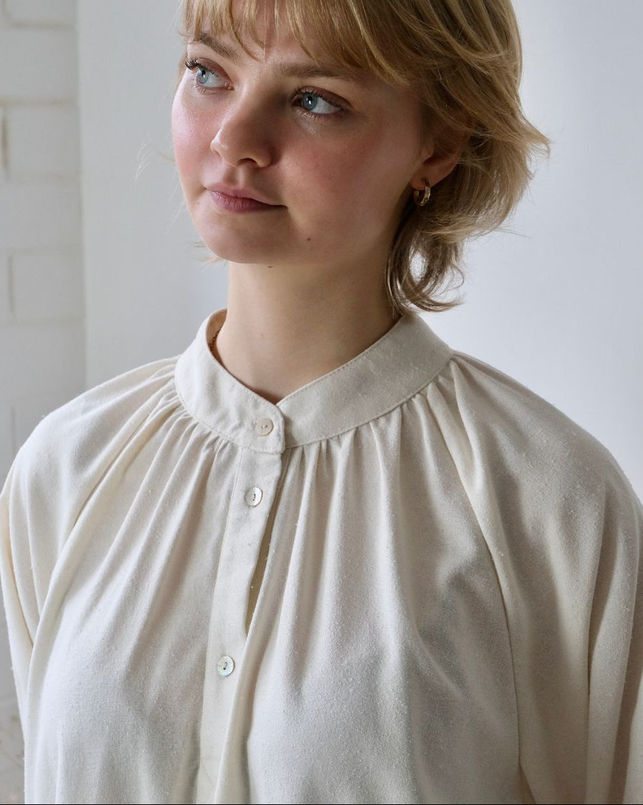 close up of person wearing shirt with rounded collar
