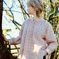 Person wearing a plaid shirt standing in a forest