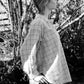 Person wearing a checkered shirt in a natural setting