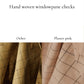 Hand woven windowpane checks fabric swatches in ochre and plaster pink on a white background.