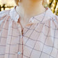 Close-up of a person wearing a plaid shirt with a blurred background