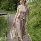 Woman in a checkered dress walking along a path in a garden