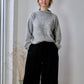 woman standing in studio wearing grey jumper and black needlecord culottes