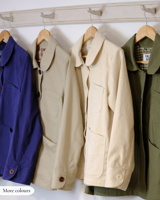 Four jackets hanging on a rack with visible brand labels.