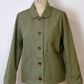 Green jacket on a mannequin with 'K-L' branding against a white background