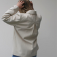 person wearing cream coloured jacket showing back view with white background