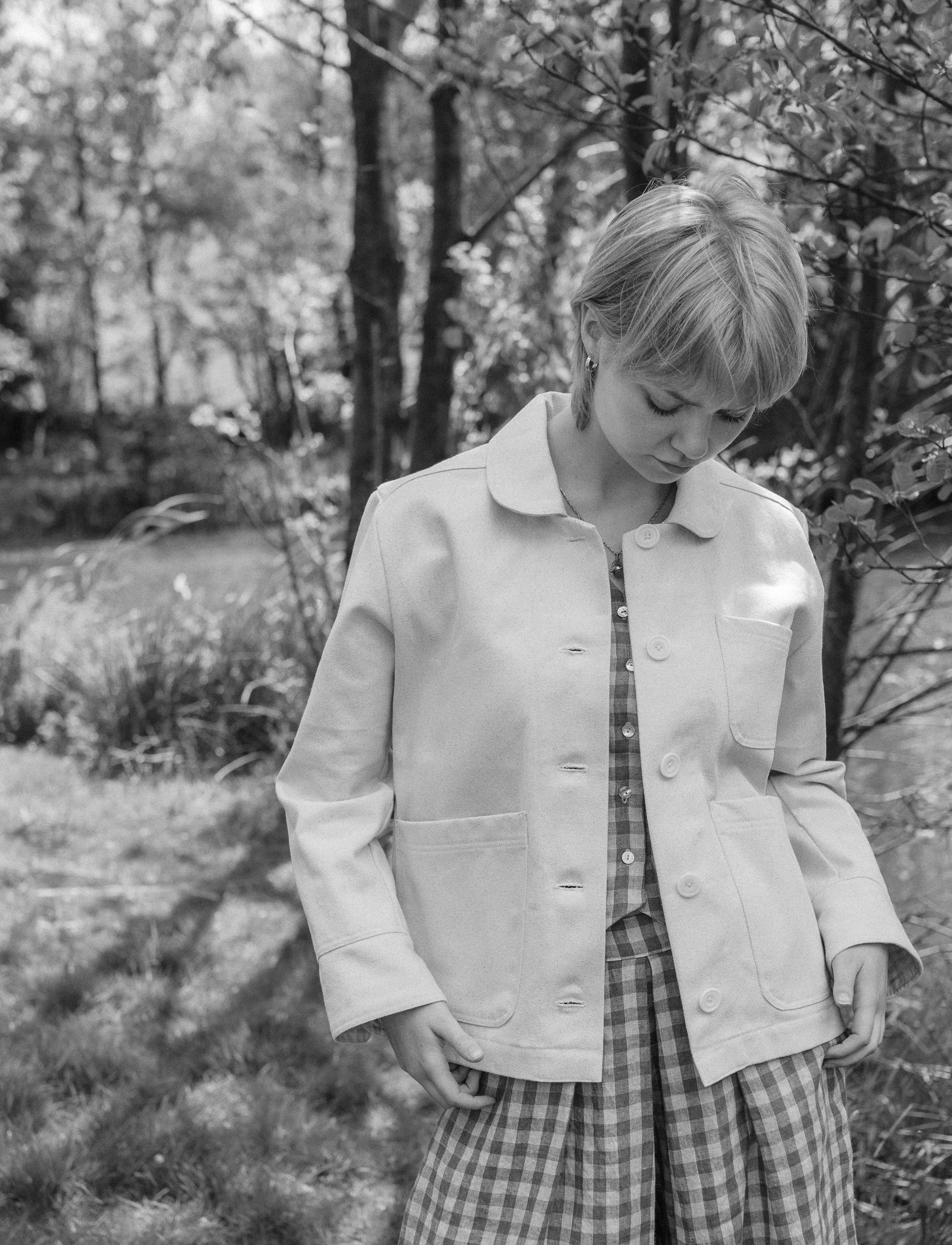 person wearing natural jacket with pockets in woodland setting.