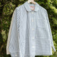 Striped shirt hanging on a hanger against a natural background