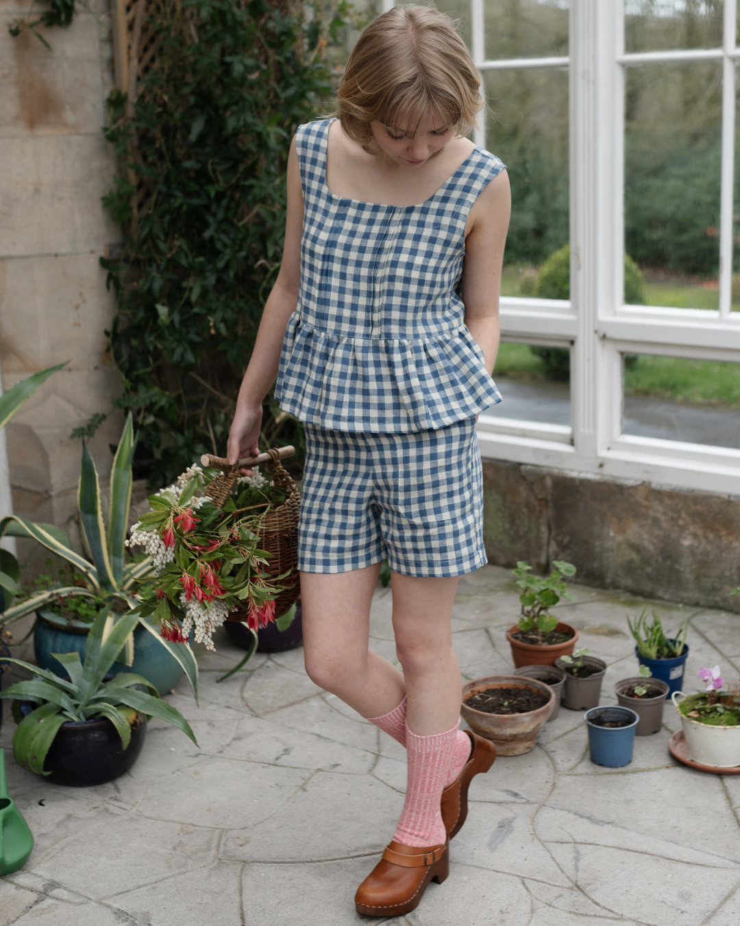 A model wearing a blue and white checkered peplum top and matching shorts. The clothing items are presented as a bundle with a save £25.