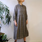 person wearing. black and natural linen check dress with a white background.