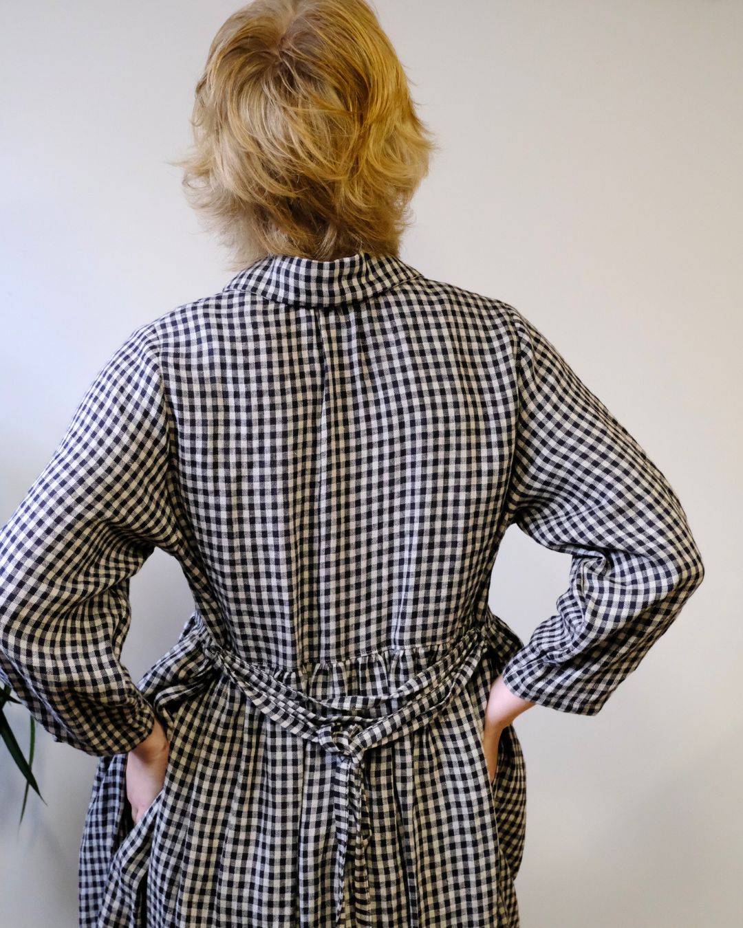 Person wearing a black and white checkered dress against a plain background