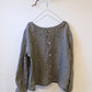 Black and grey check top on a hanger with buttoned back against a white background.