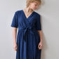 Woman wearing a blue dress against a plain background