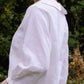 Person wearing a white shirt with a blurred natural background