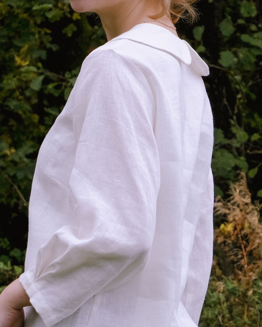 Person wearing a white shirt with a blurred natural background