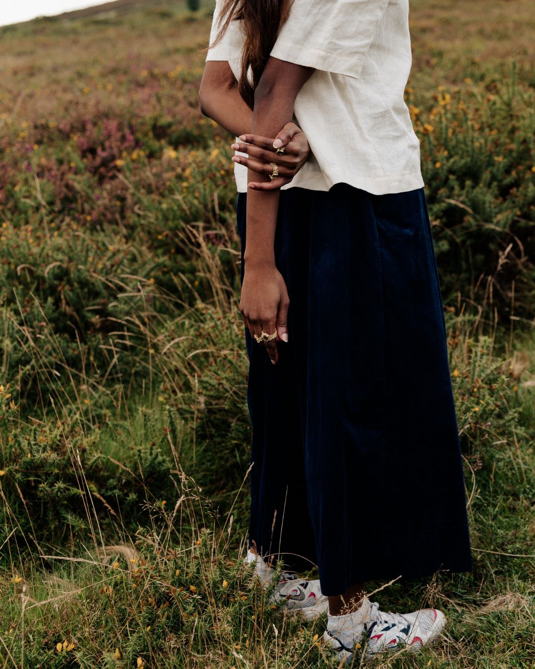 woman standing in countryside wearing navy needlecord culottes